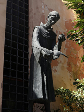 Statua moderna in bronzo di San Francesco d'Assisi con uccellino, scultura religiosa contemporanea dedicata al patrono d'Italia e della natura, situata a Tivoli nel Lazio, simbolo di pace e spirituali