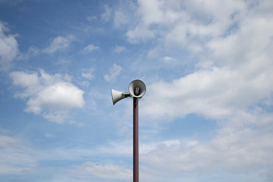 Outdoor emergency broadcast speakers against vast cloudy sky