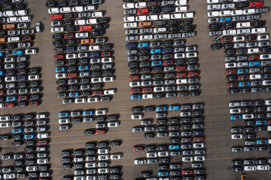 Aerial view of thousands of new cars parked in neat rows at the port terminal with various colors under bright daylight Antwerpen, Vlaanderen, Belgium.