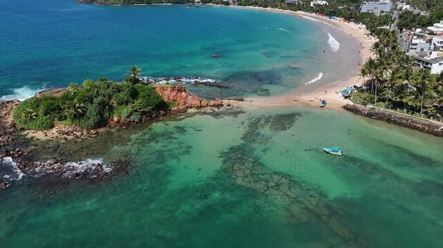 Aerial view of a sandspit with transparent turquoise water on both sides. Mirissa, Sri Lanka