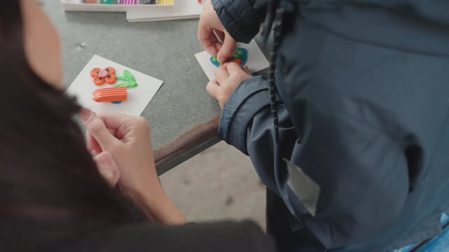 Child and therapist collaborate on developing fine motor skills in craft tasks. Pediatric patient and therapist jointly practice bead placement techniques to promote motor development