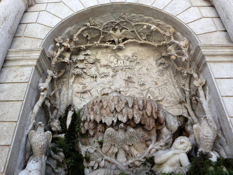 Dettaglio scultoreo in pietra calcarea della Fontana della Civetta a Villa d'Este con rilievi di uccelli e rami intrecciati all'interno di una nicchia