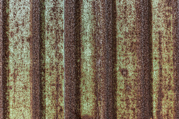 Obraz premium Vintage rusty corrugated metal wall texture background with weathered industrial iron sheet and green paint for architectural design