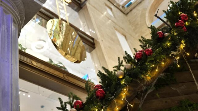Decorated fir branches against the backdrop of a swinging clock pendulum.