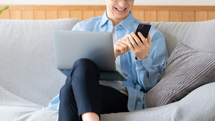 パソコンとスマートフォンを使う男性のビジネスイメージ, Man Using Laptop and Smartphone Business Concept © Trickster*