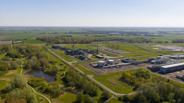 Aerial view of the NAM Grijpskerk UGS facility with industrial tanks and infrastructure surrounded by lush green fields and trees Grijpskerk, Groningen, Netherlands.