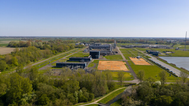 Aerial view of the NAM Grijpskerk UGS industrial facility with processing units and storage tanks surrounded by green fields and trees in Grijpskerk, Groningen, Netherlands.