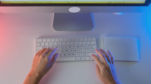 Top view of female hands working on desktop computer with keyboard and mouse, minimal clean workspace with colorful gradient lighting, office workflow, digital tasks and modern technology concept