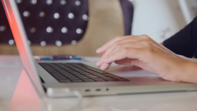 Woman hands typing on laptop keyboard in close-up side view, entering text and working online, modern digital workflow, remote job, communication and everyday computer usage
