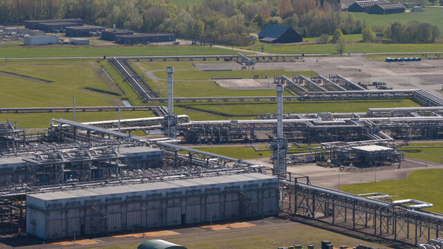 Aerial view of the NAM Grijpskerk UGS facility featuring complex industrial piping, chimneys, and storage structures surrounded by green fields in Grijpskerk, Groningen, Netherlands.