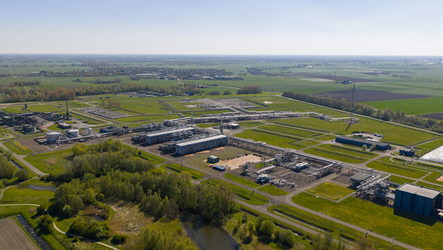 Aerial view of the NAM Grijpskerk UGS facility with industrial pipelines and storage tanks surrounded by green fields in Grijpskerk, Groningen, Netherlands.