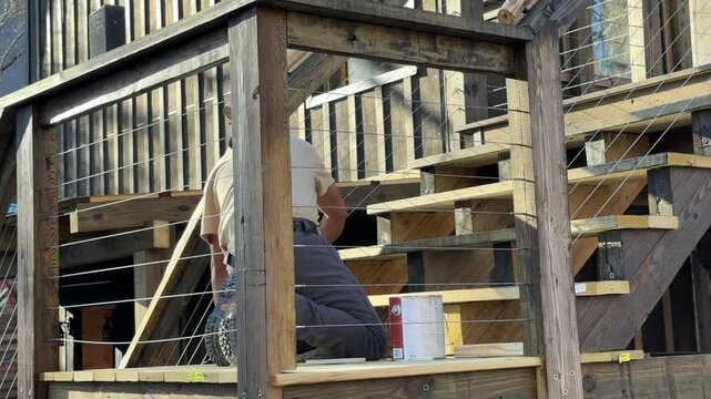 Man staining stairs dark brown
