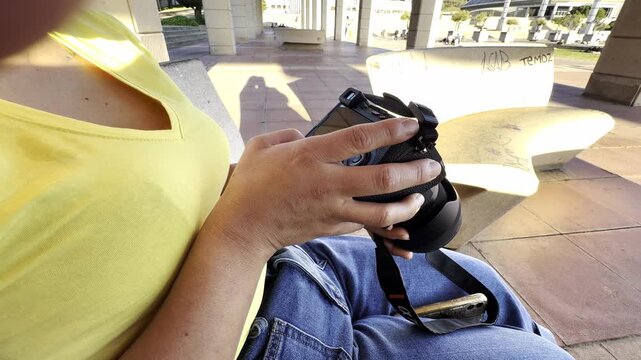Latin woman photographer reviewing pictures on her mirrorless camera display