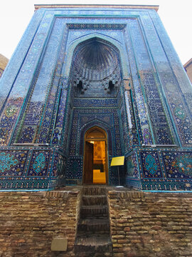 Ornate tiled facade of a mausoleum at Shah-i-Zinda necropolis in Samarkand featuring intricate blue and turquoise tilework. Ideal for travel publications, cultural heritage materials.