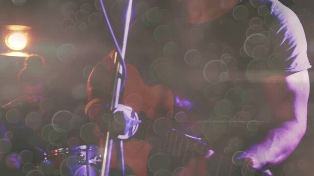 Photographer raising DSLR and aiming, capturing music band while animated bokeh over singer, drums