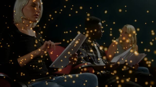 Left woman turning scripts and reading cueing rehearsal camera pulling back gold overlaying faces