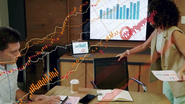 Woman standing pointing monitor showing bar chart to explain business data while man taking notes