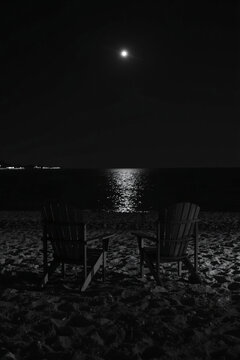 Moonlit Night on Beach with Adirondack Chairs by Calm Water Reflect