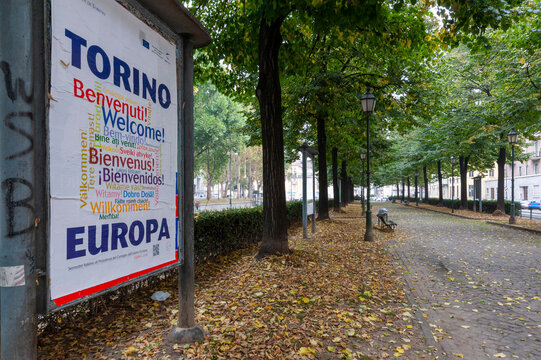 Torino, Italia - 28/09/2014  Cartello di benvenuto multilingue lungo un viale alberato. Immagine che rappresenta accoglienza, identit&agrave; europea e atmosfera urbana autunnale.