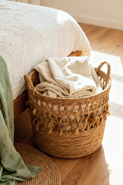 Woven Basket with Linen Throw Next to Bed in Bright, Minimalist Home