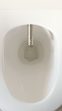 Clean White Urinal With Sensor Flush. Closeup Sequence Showing Automatic Flush Nozzle Activating Over Porcelain Bowl, Stainless Hardware, Soft Clinical Lighting, Minimal Design. Series Captures