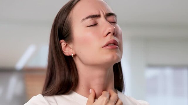 Young Woman Gently Touches Her Neck