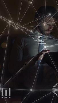 Vertical video: Business exec tapping tablet causing HUD node web and chart shifts reviewing data