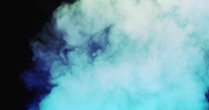 Soft blue smoke spreads across a dark background creating a dramatic abstract atmosphere.