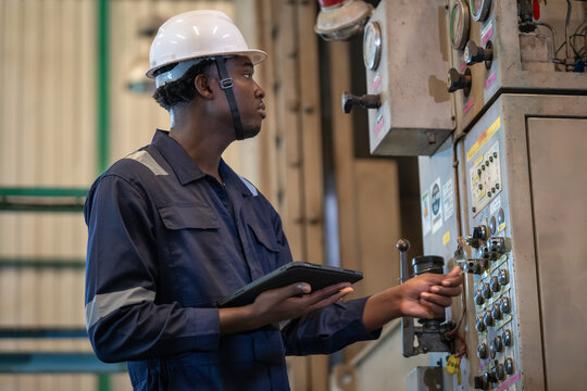 Industrial operator monitoring equipment factory photo indoor side view efficiency and safety in action
