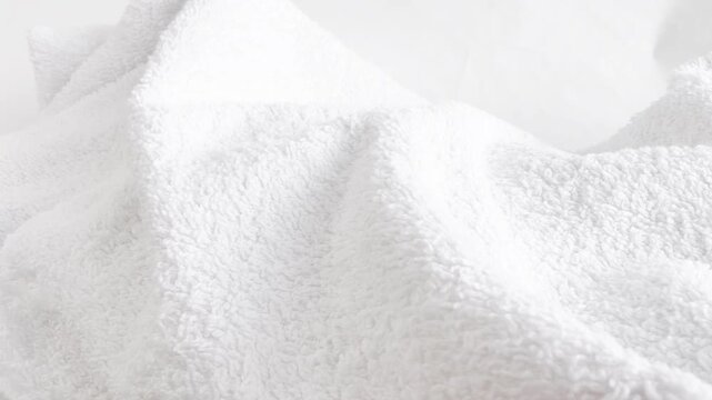 Clean white towels with soft folds stacked in a neat pile, perfect for bathroom, laundry room, or hotel linen storage and fresh textile care.