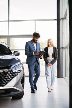 Salesman consulting woman customer buying new car