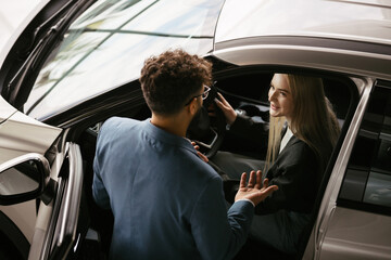 Car salesman assisting woman trying new automobile © dsheremeta