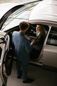 Car salesperson consulting woman choosing a new car