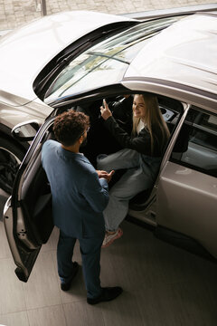 Woman buying new car at modern dealership