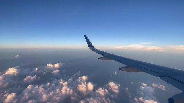 Airplane Wing Over Cloudscape with Blue Sky Aerial View
