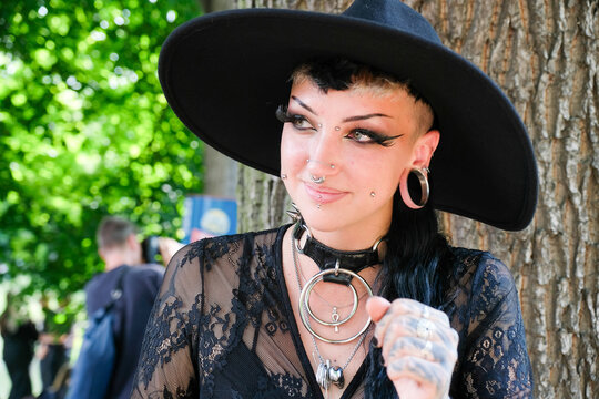 Portrait of a gothic woman with piercings, stretched ears, bold makeup on the annual Wave Gotik Treffen (Wave Gothic Meeting) in Leipzig, victorian picnic, Clara-Zetkin-Park