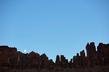 Naklejka premium Desert canyon rock formations under clear moonlit sky