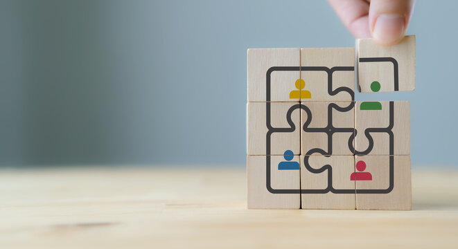 Team integration and organizational synergy concept. Placing wooden block with people icons, symbolizing partner, team integration, collaboration and building a complete, connected organization.