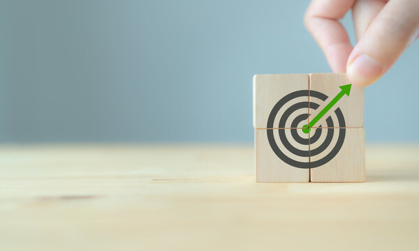 Precision Goal Setting and Growth Focus. Wooden blocks forming a target with upward arrow, symbolizing precise goal setting, strategic alignment and steady growth through focused execution.