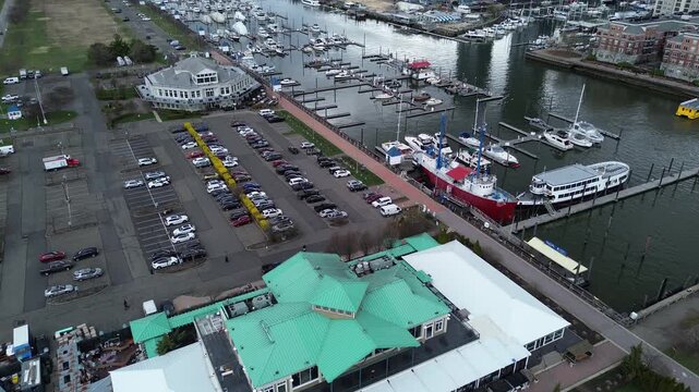 Canal edge activity shows Morris Canal Basin near Liberty Landing Marina with clustered docks, parking rows, green roof service buildings Audrey Zapp Dr. Boat decks, pavement grids, New Jersey
