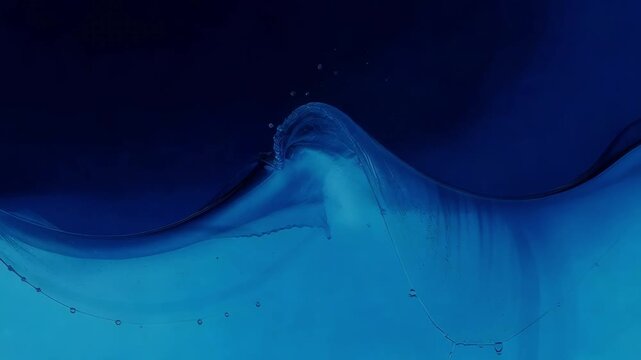 Slow motion close up of blue liquid wave forming and collapsing in studio tank