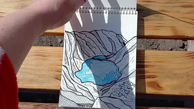 Hand flipping through a sketchbook with drawings