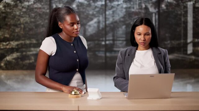 Hotel Manager Trains New Receptionist On Laptop