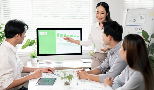 Businesswoman presenting an ESG sustainability report to team in office.