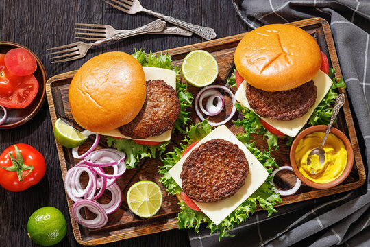 beef cheeseburgers with brioche buns on a tray