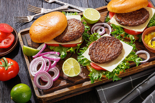 beef cheeseburgers with brioche buns on a tray