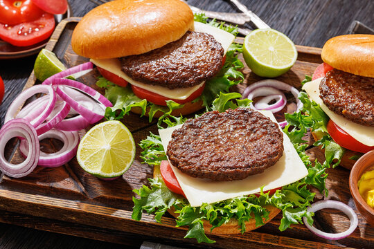 beef cheeseburgers with brioche buns on a tray