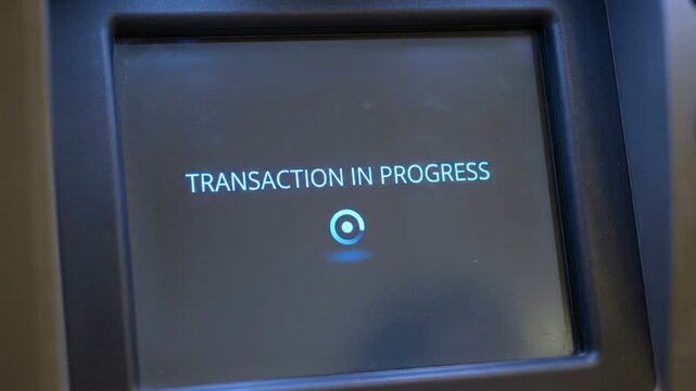 ATM transaction in progress screen with loading circle.