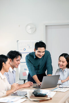 Happy Asian Business Team Collaborating on Laptop in Modern Office