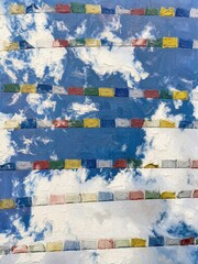 Naklejka premium Prayer Flags Under Blue Sky: Impressionist Oil Painting of Colorful Buddhist Flags